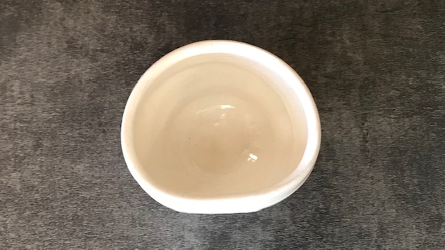 白くてロクロ目がある湯飲みを少しだけ片押しした形です。